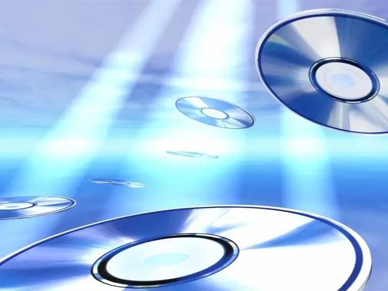 Floating CDs shimmer under blue light beams against a sky backdrop. Futuristic and ethereal.